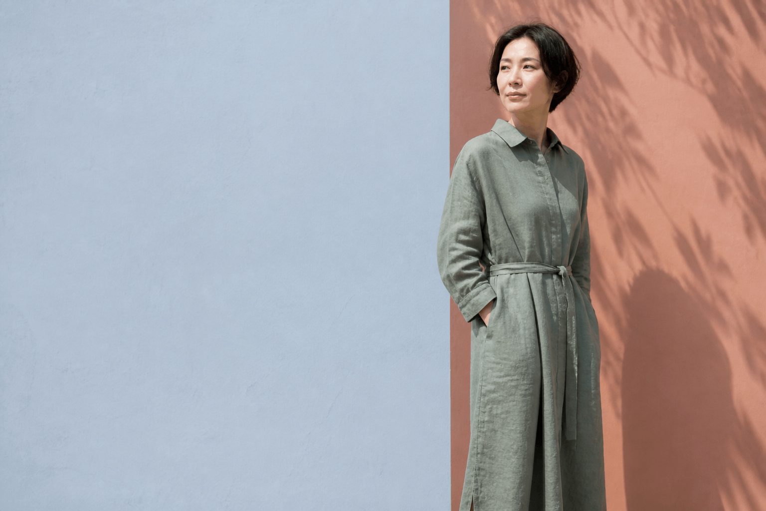 セージグリーンのリネンワンピースを着た女性